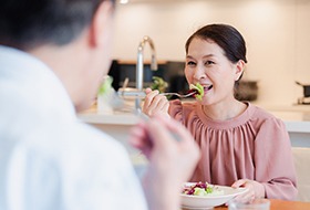 Woman with dentures eating a salad