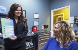 Dental team member showing a paper to a patient