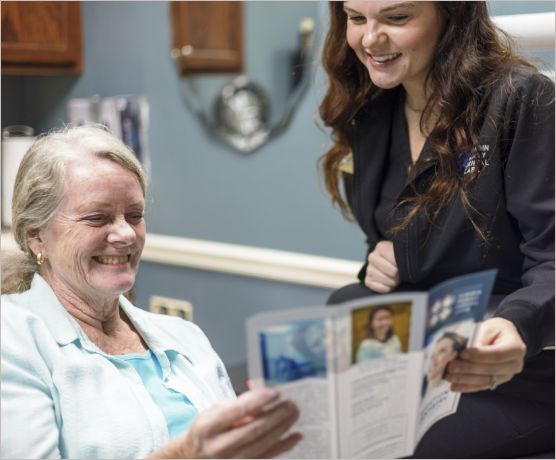 Dental team member showing a pamphlet to a patient