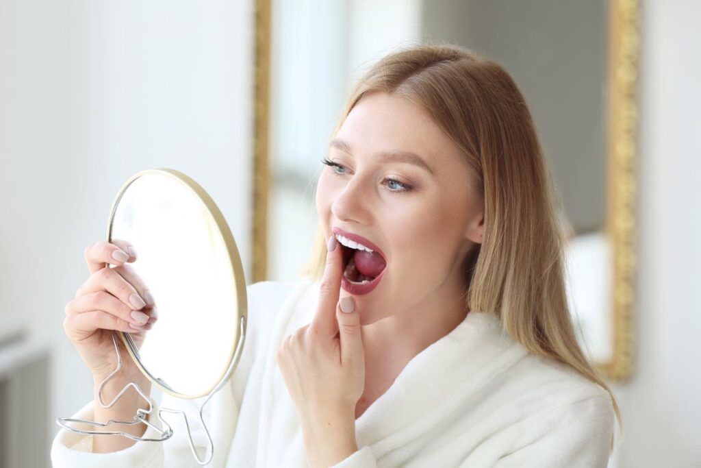 A woman looking at her teeth in the mirror