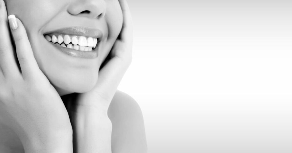 A black and white image of a woman smiling.